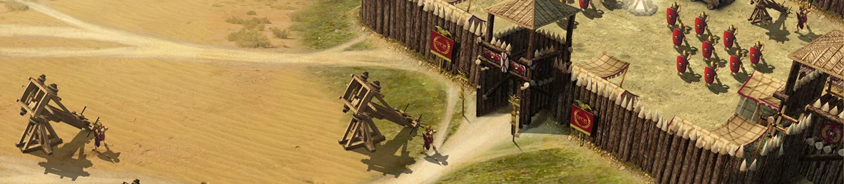 Obrázek ze strategické hry zobrazující římský vojenský tábor s dřevěnou palisádou, vojáky s červenými štíty a katapulty v pouštní krajině